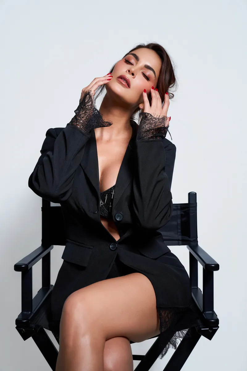 Laura Spoya con blazer negro apoyando la mano en el rostro